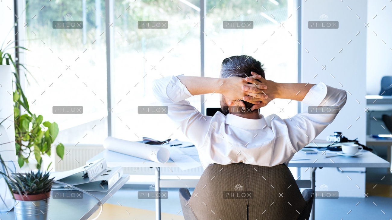 Businessman-at-the-desk-in-his-office-resting.