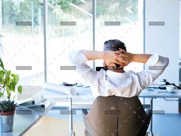 Businessman-at-the-desk-in-his-office-resting.