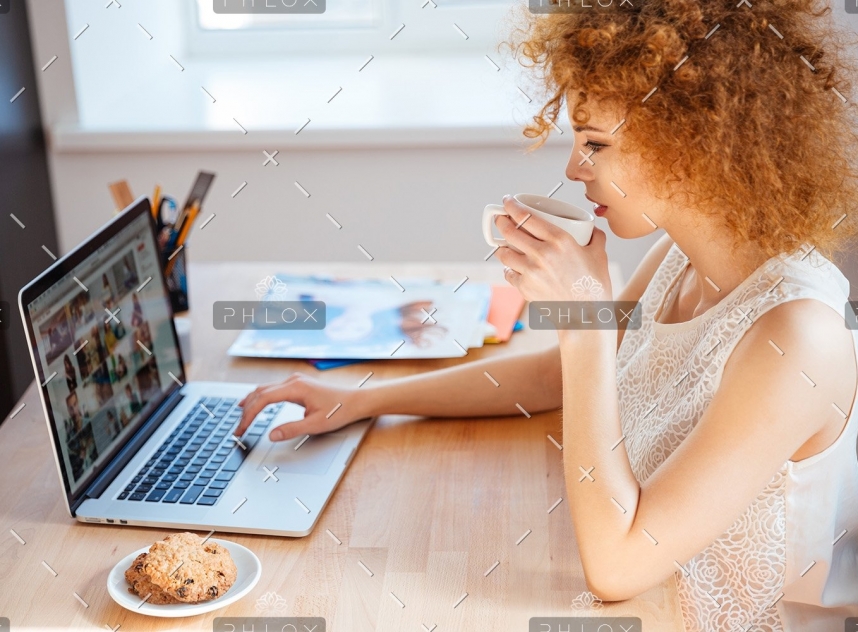 woman-photographer-drinking-coffee-and-working-PJNBP6U